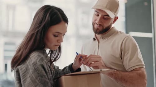 Woman Signs for Package from Delivery Man