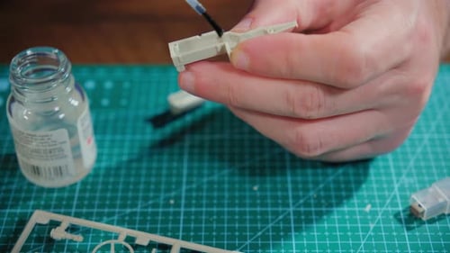 Close Up View Footage of Hands of Man Assembler Plastic Model at Table Hobby Time
