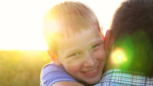 Happy Child Hugs Adult in Golden Sunlight
