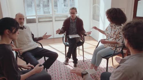 Therapist and Patients Sitting in Circle and Holding Hands in Group Therapy