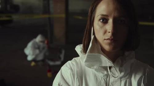 Woman in Protective Suit at Dark Crime Scene