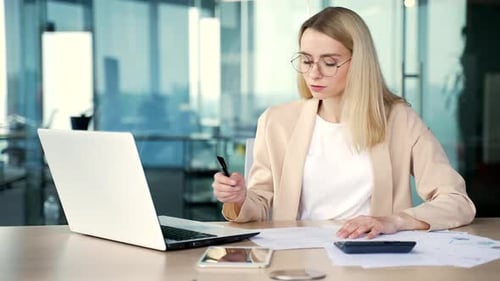 Woman Works on Laptop in Modern Office
