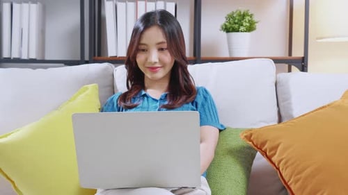 Woman Using Laptop Computer in Home Living Room