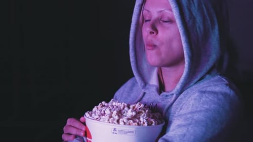 Blonde Woman Eating Popcorn and Watching Movie
