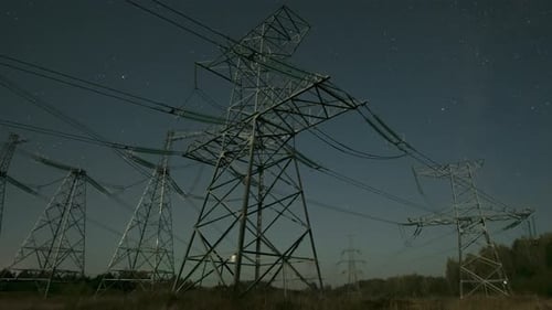Nighttime View of Power Lines Against a Starry Sky in a Remote Area with Clear Visibility of