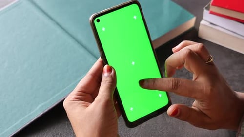 Person Interacting with Smartphone on Green Screen Background