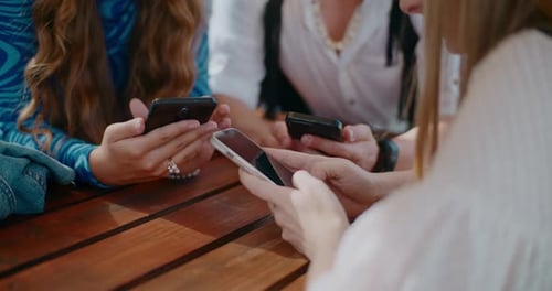 Junge Freunde benutzen Smartphones auf dem Tisch