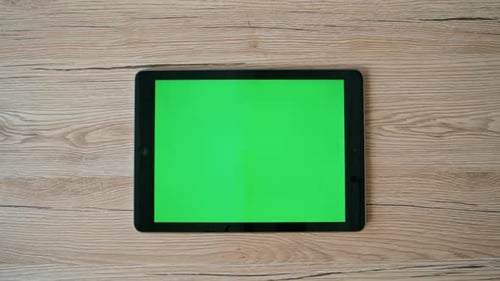 Closeup Hand Swiping Greenscreen Tablet on Office Table Unknown Businesswoman