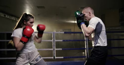 Female Boxer Practicing Punches With Male Trainer
