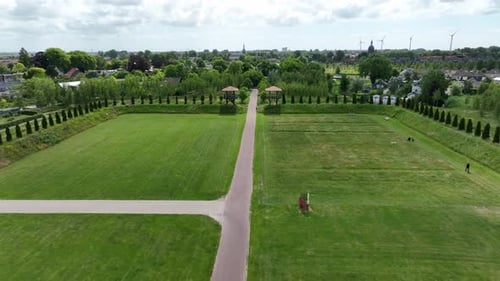 Aerial Drone View of Symmetrical Green Park Pathway Leading to Town