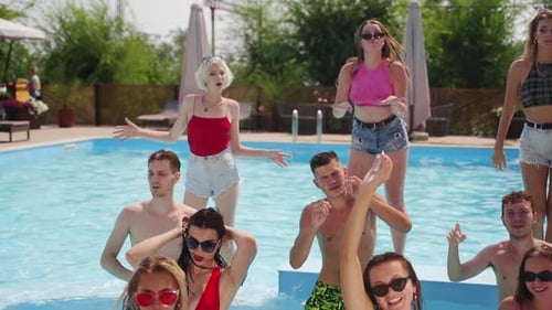 Female and Male Models Chilling in Swimming Pool Splashing Water Flirting and Posing for Photoshoot
