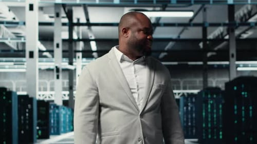 Smiling Manager in Data Center Doing Checkup on Hardware to Avoid Downtime