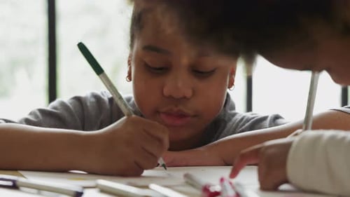 Children drawing with markers at home at daytime