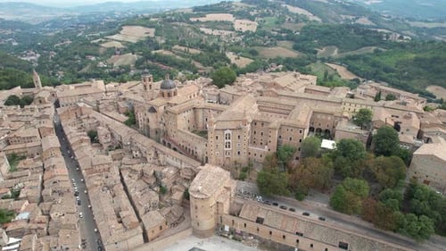 An expansive aerial view of Urbino’s front entrance, showcasing its historic architecture and near l