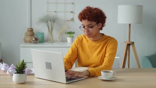 African American Girl Using Laptop at Home Office Looking at Screen Typing Chatting Reading Writing