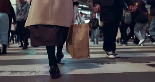 Füße, Gehen und Frau in der geschäftigen Stadt mit Tasche für die Arbeit mit Reisen auf der Straße mit Menschen