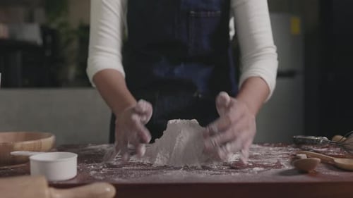 Der Koch mischt das Mehl, indem er das Brot von Hand nach der Rezeptur zubereitet
