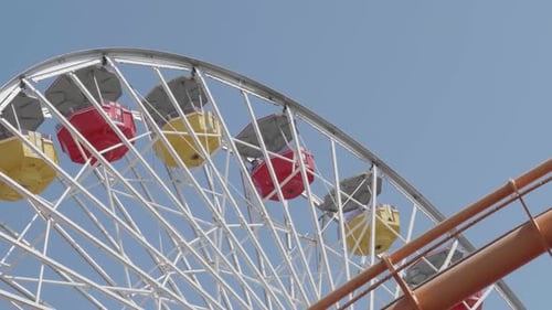 Ferris wheel turning as seen from the ground.