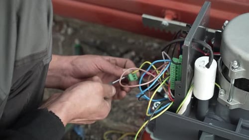 Hands Wiring Electrical Machine with Colored Wires
