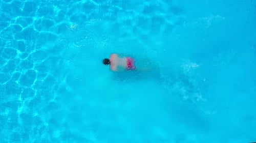 Luftaufnahme als Mann in den Pool taucht und schwimmt
