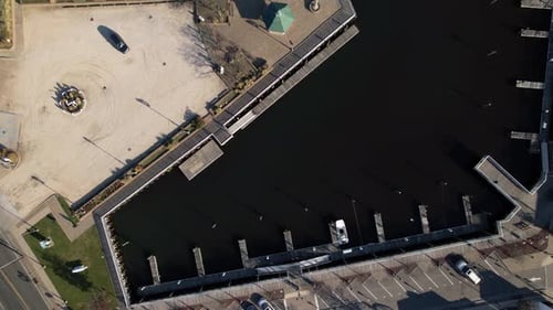 A top down view directly above a park with gravel and a boardwalk on the water. Taken on a sunny day