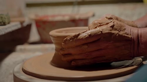 Glose Up Hands Working Clay on Potter's Wheel Tasse en céramique en forme de bras humains qui tourne