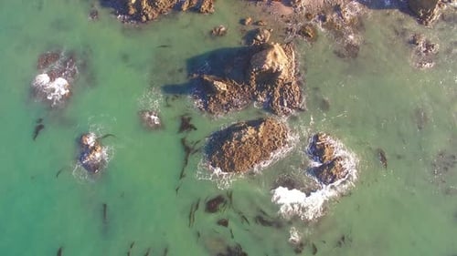 Aerial View of Ocean Waves Crashing Against Rocks