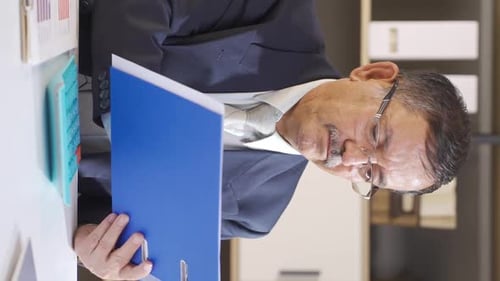 Vertical video of Businessman looking at files.