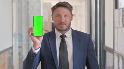 Portrait of Middle Aged Businessman Holding Phone with Green Screen