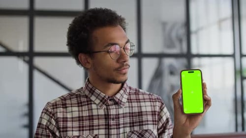 Man Holding Smartphone with Green Screen Display