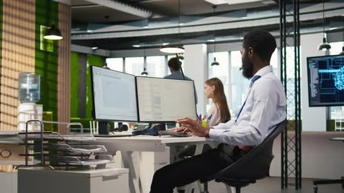 Un administrateur de Tech Startup Office utilise un PC pour compiler des correctifs logiciels pour corriger les bogues