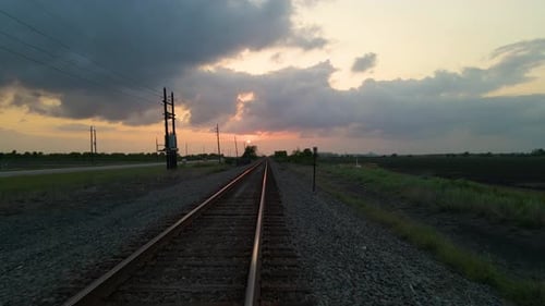 Drone Shot Following Low Over Empty Railroad Tracks Toward Setting Sun In Texas, U.S.A.