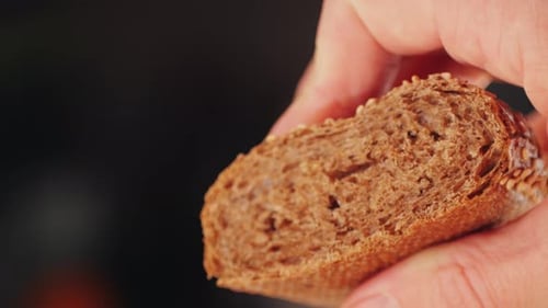 Close Up of Dark Bread Slice in Hand