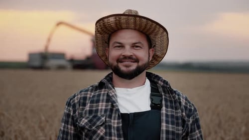 Agribusiness and Agriculture Portrait of Joyful Farm Worker Smiling to Camera Harvester Machine