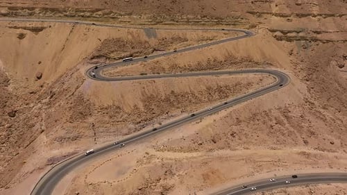 Day traffic going up and down a desert mountain winding road, Aerial view