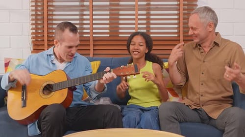 Family Sings Along with Guitar in Living Room