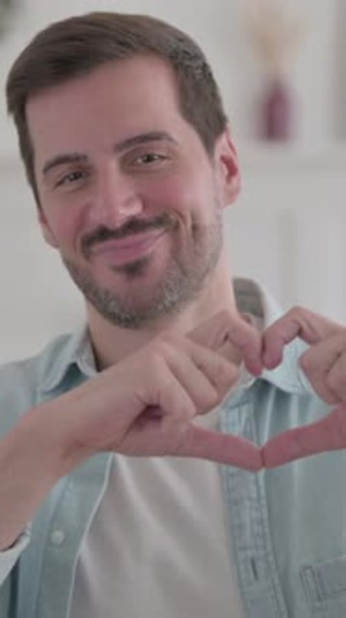 Man Shows Heart Shape With Hands, Affectionate Gesture