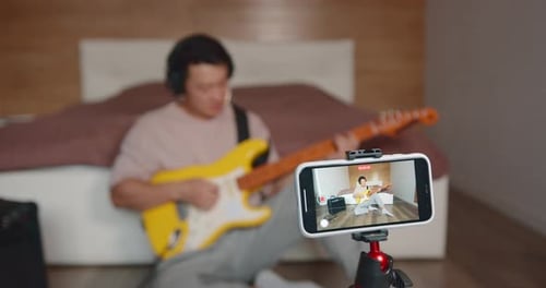 Young Adult Plays Electric Guitar, Records Video