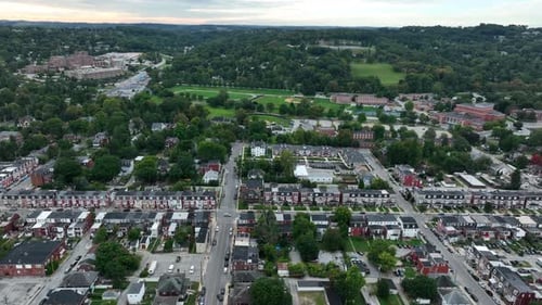 High aerial of American city. Compact residential housing district with homes along street in evenin