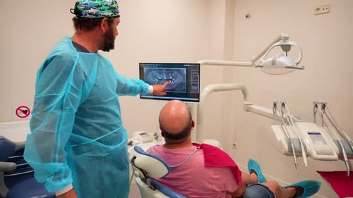 Male dentist doctor explaining an oral x-ray to his patient in the clinic