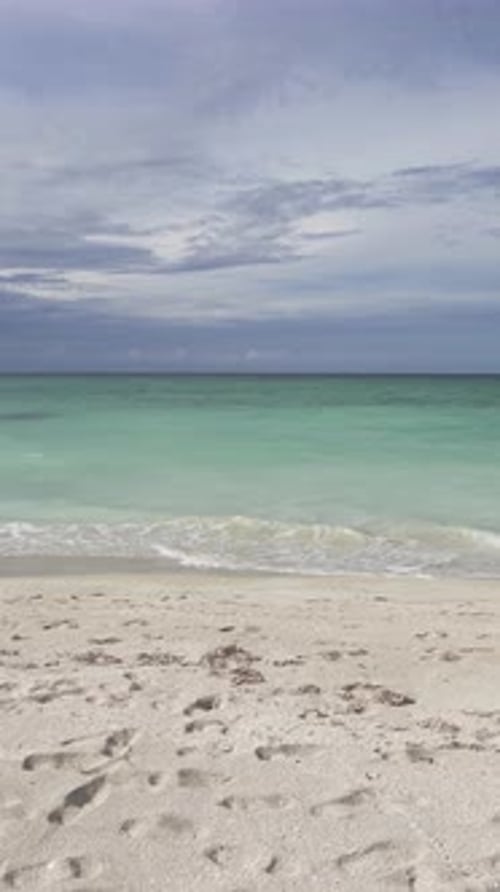 Caribbean sea, Atlantic ocean with mild waves and blue cloudy sky, vertical video