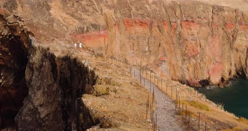 Couple Walking In Scenic Landscape Of Ponta De Sao in Madeira Portugal - wide shot