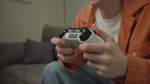 Focused Young Adult Playing Video Game at Home