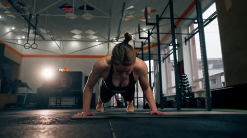 Faces In the Gym Girl Trainer Does Pushups on the Floor Directly at the Camera