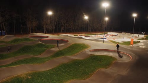 Children Ride Kick Scooters and Skates in Night Park