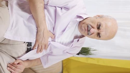Vertical video of Old man with nausea.