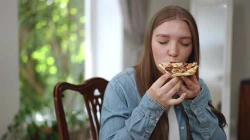 Young Adult Enjoying a Delicious Slice of Pizza