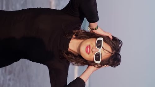 Stylish Woman Walks on Beach Wearing Sunglasses