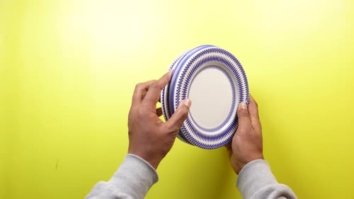 Top View of Holding Round Bowl or Ceramic Plate on Yellow Background