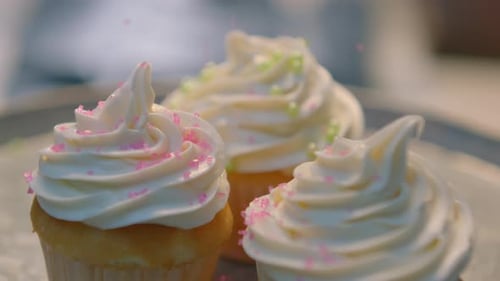 Pink Sprinkles Being Added to Cupcakes